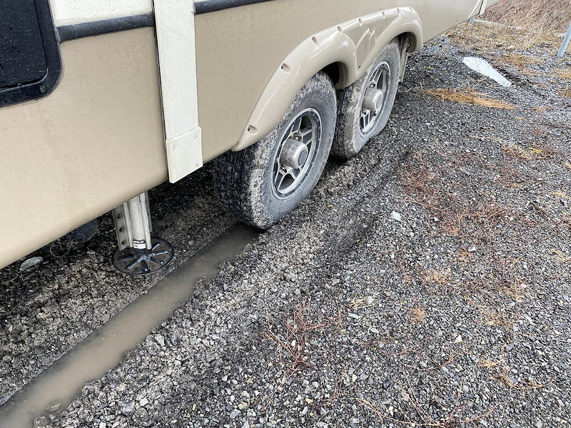 After backing our trailer into its spot at our storage yard, we discovered that the tires on one side had sunk into the gravely mud.